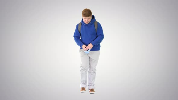 Teenager Walking and Taking Off Medical Mask on Gradient Background