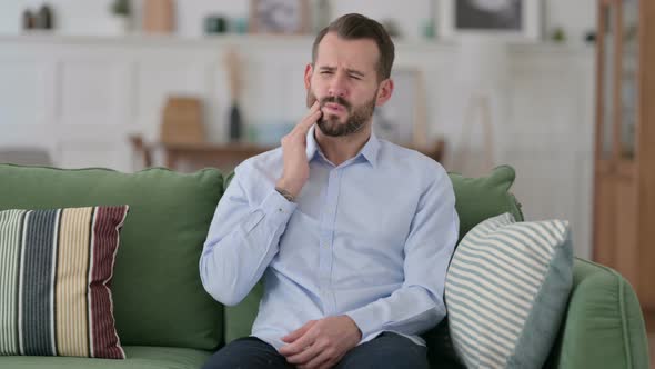 Allergic Young Man Having Toothache, Cavity on Sofa 