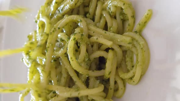 Spaghetti with Pesto Sauce Being Served with a Spaghetti Spoon