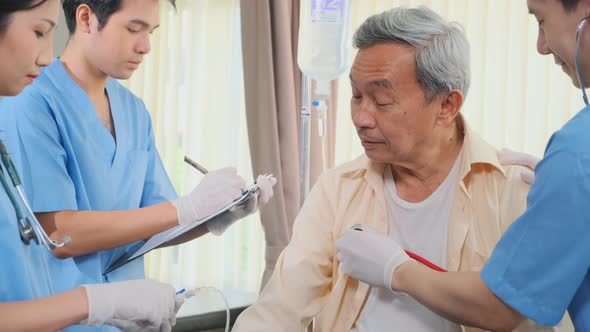 Asian medical team doctors nurse examining and checking Asian elderly male patient