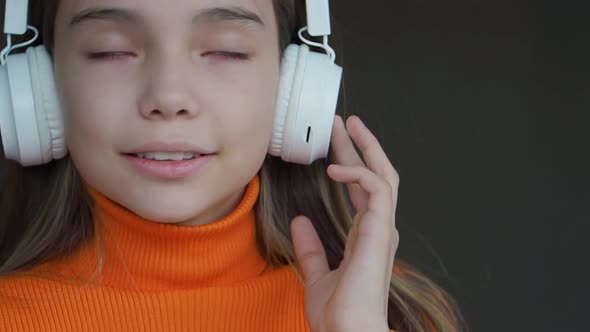 Teenager Girl Listening to the Music Via Wireless Headphones and Online Smartphone App Indoor