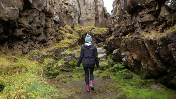 Authentic Shot Following a Young Female Tourist Through a Canyon.