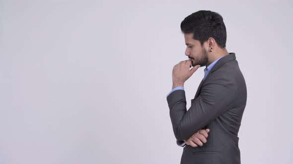 Profile View of Young Handsome Bearded Indian Businessman Thinking