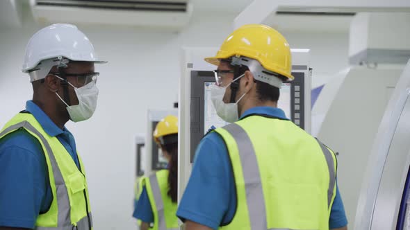 Group of diversity worker people wearing protective face mask in production factory due to covid 19.