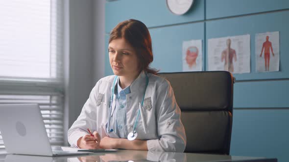 Professional lady doctor conducts online checkup talking to patient