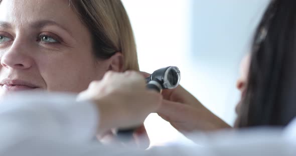 ENT Doctor Conducts Medical Examination of Ear with Otoscope Closeup