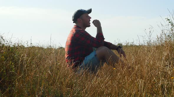 Grass Front Background. Pensive Lonely Guy In The Field. Young Sad Man Sitting In The Tall