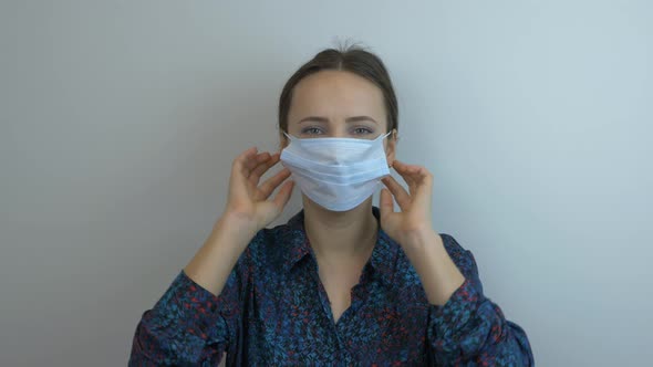 Woman in protective medical face mask shows stop sign with hand. Stop coronavirus.