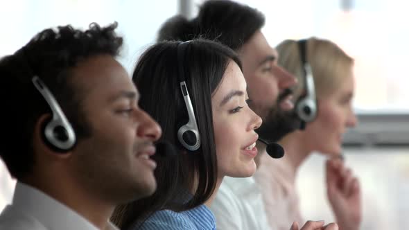 Female Asian Dispatcher Working Amoung Collegues.