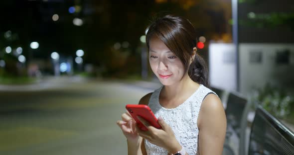 Woman use of mobile phone at outdoor in the evening