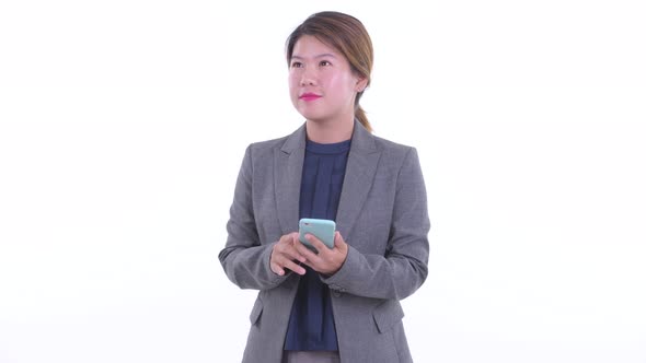 Happy Young Asian Businesswoman Thinking While Using Phone