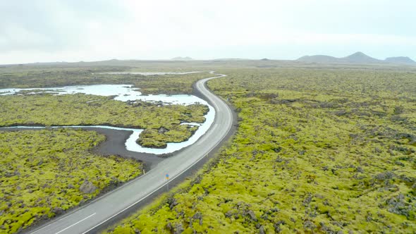 Vacant Road Amidst The Green Landscape In Reykjanes Peninsula In Southwestern Iceland. aerial