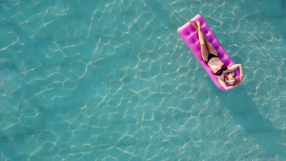 Young Pretty Woman on Air Mattress in the Pool