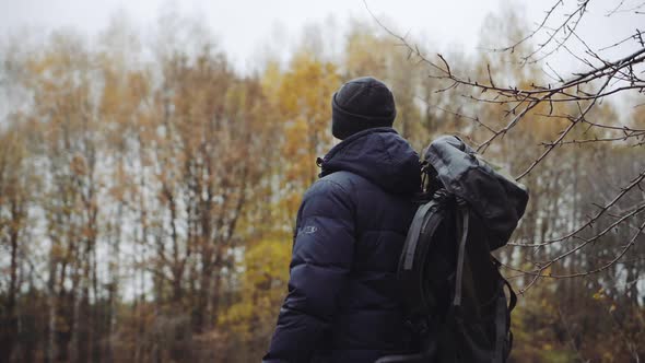 Walking male backpacker tourist. Travel and healthy lifestyle outdoors in fall season nature