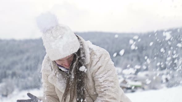 Young Beautiful Woman is Spinning and Someone is Sprinkling Snow on Her