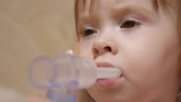 Child Is Sick and Breathes Through an Inhaler. Toddler Treats Flu By Inhaling Inhalation Vapor