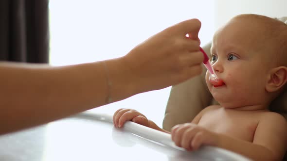 Closeup Portrait Baby Eating Soup From Spoon Making Funny Face Tasting Food