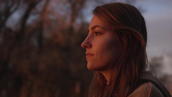 Close view of teenage girls face during sunset at she looks around