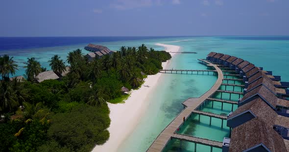 Wide angle aerial tourism shot of a white sandy paradise beach and aqua blue water background 