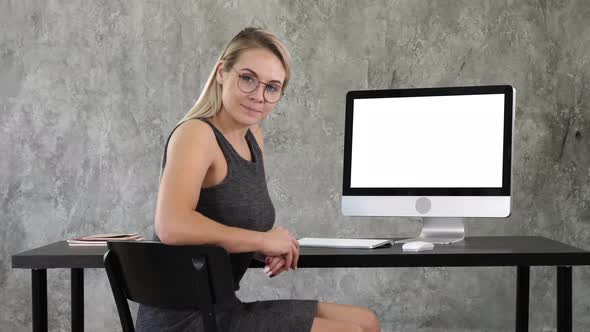 Pretty Businesswoman Looking at Camera Near Computer Screen