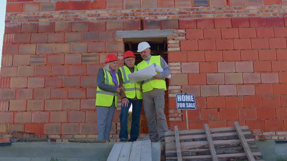 Realestate Agent Selling New House to Senior Grandmother Grandfather Showing Building Blueprints