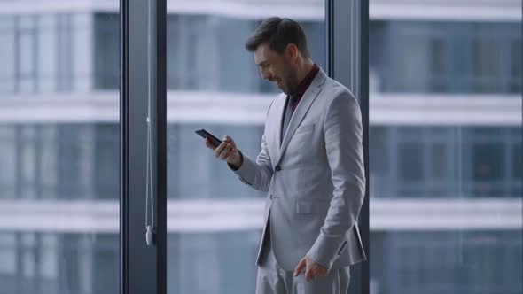 Excited Corporate Man Celebrate Business Success Talking Phone By Window Office