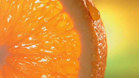 Drop of Water Flows Down the Surface of a Ripe Juicy Orange Slice
