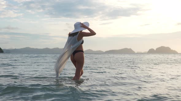 Young Woman In Thong And Sun Hat In Sea