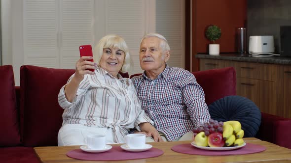 Senior Family Having Fun, Making Selfie Photos, Recording Video Together on Smartphone at Home