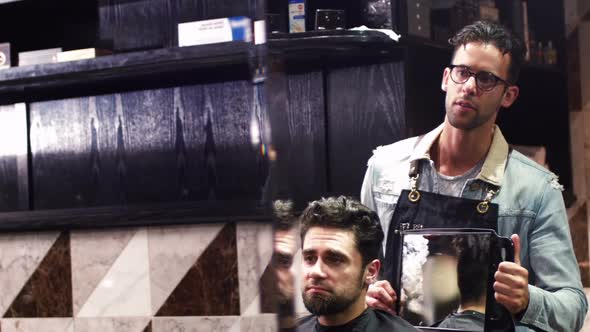 Hairdresser showing client his haircut in mirror