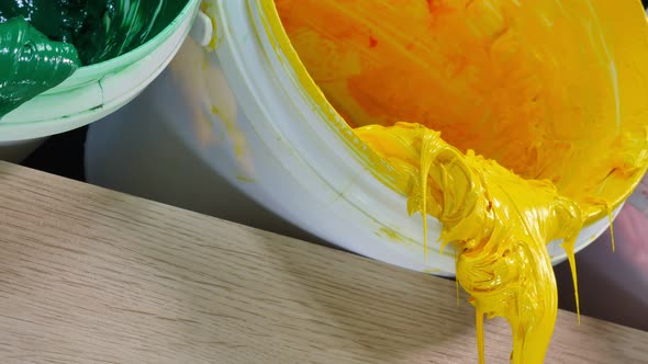 Close Up Yellow Ink In White Bucket Are Driping.