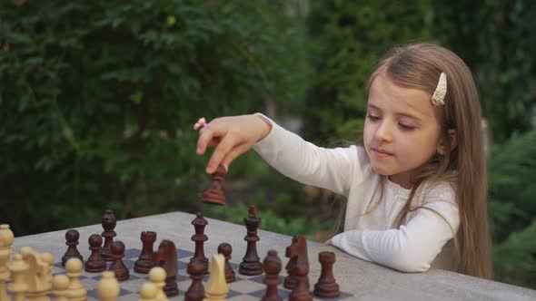 Close Up Cute Little Girl Playing Chess Outdoor