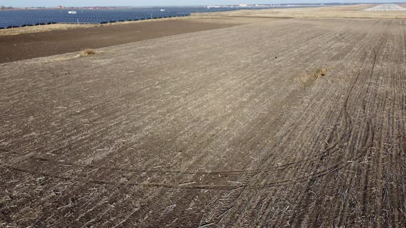 Aerial Drone View Flight Over Field of Plowed Brown Earth