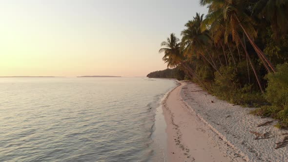 Aerial: uncontaminated white sand beach sunset at Kei Islands Maluku Indonesia