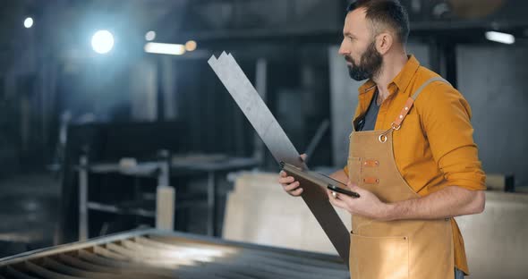 Factory Worker with Tablet and Phone at the Manufacturing