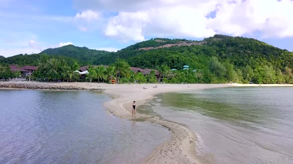 Young Pretty Woman in Black Swimsuit Walking Alone on a SandbarThailand