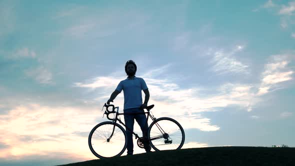 Man with Bicycle Against Beautiful Sky