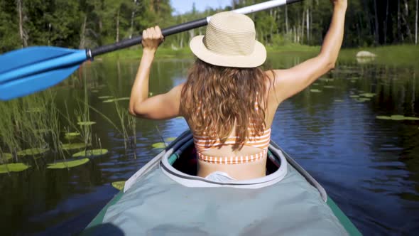 Beautiful Young Woman Kayaking on Lake