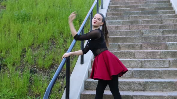 Amazing female dancer dances on the stairs outside