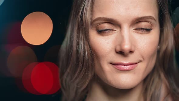 Closeup Face of Woman Posing Isolated on Black Studio with Colorful Glow Bokeh