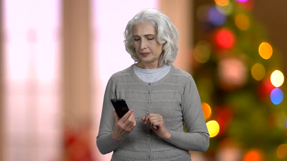 Smiling Senior Woman Using App on Her Smartphone