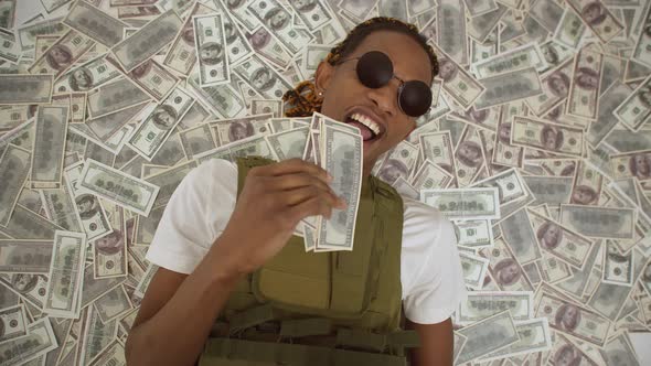 Black Man is Lay on a Pile of Dollar Bills Banknotes Fall on Man