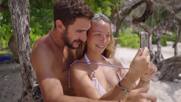 A Close Up Shot of a Happy Romantic Couple on the Beach Taking Photo of Themselves with Smart Phone