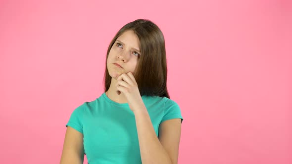 Little Woman Is Thinking in Studio on Pink Background.