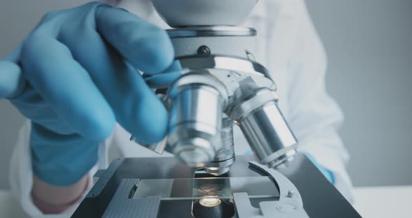 Close Up Shot of the Scientist Studies Examining of Test Sample Under the Microscope.