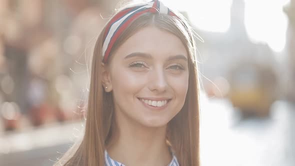 Close Up Portrait of Young Good Looking Girl with Brown Hair and Headband Wearing in Striped Dress