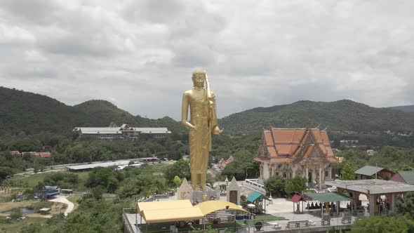 Huge Golden Buddha Statue standing on Hilltop next to Wat Khao Noi (Hua Hin), Orbiting Shot