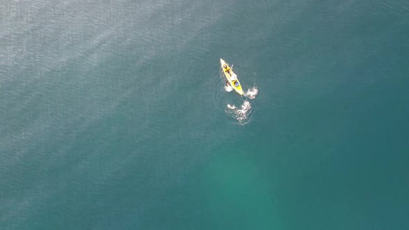 Fisherman trolling in kayak at mediterranean sea aerial drone view in middle of ocean.