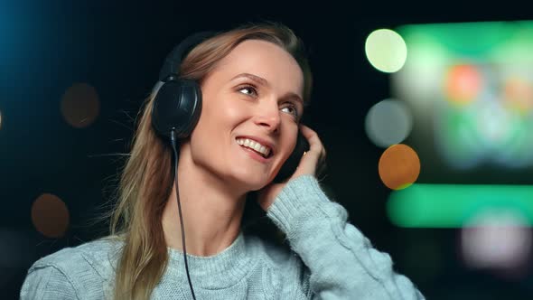 Happy Female Wearing Headphones Enjoying Sound at Night City