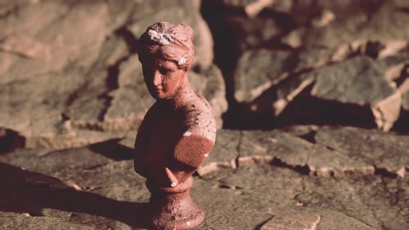 Ancient Statue of Woman on Rocky Stones alt